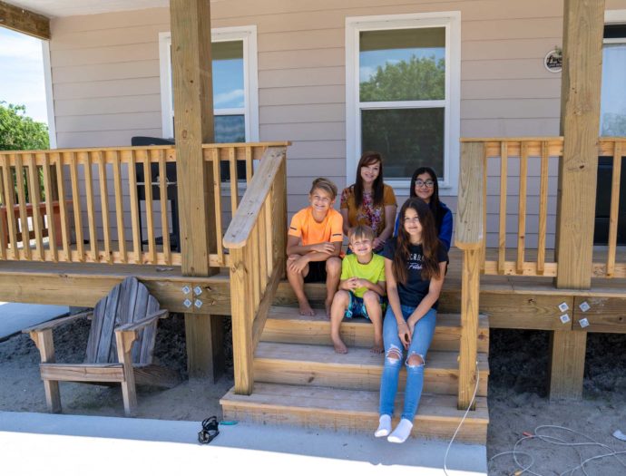 A group of people sitting on a front porch.