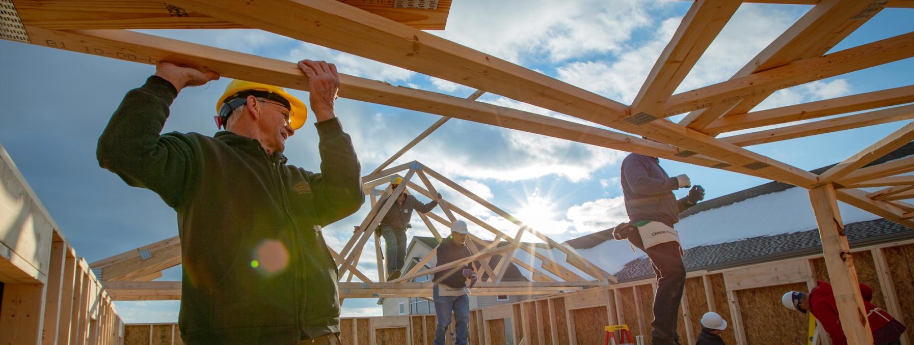 Volunteers building house frame