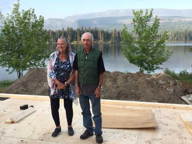 A couple stand in front of the overlook of their new home.