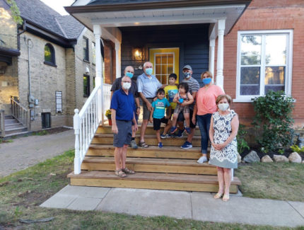 A group of people standing in front of a house.