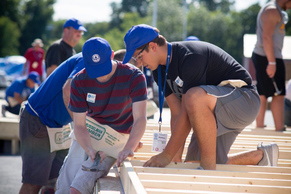 Photo of young volunteers building a wall for a home.