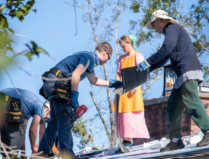 Photo of volunteers replacing a shingles on a roof in Mariana, Florida.