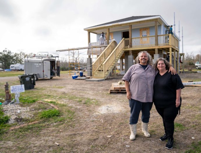 Homeowners standing in front of their house in the process of being built in Dulac, Louisiana.