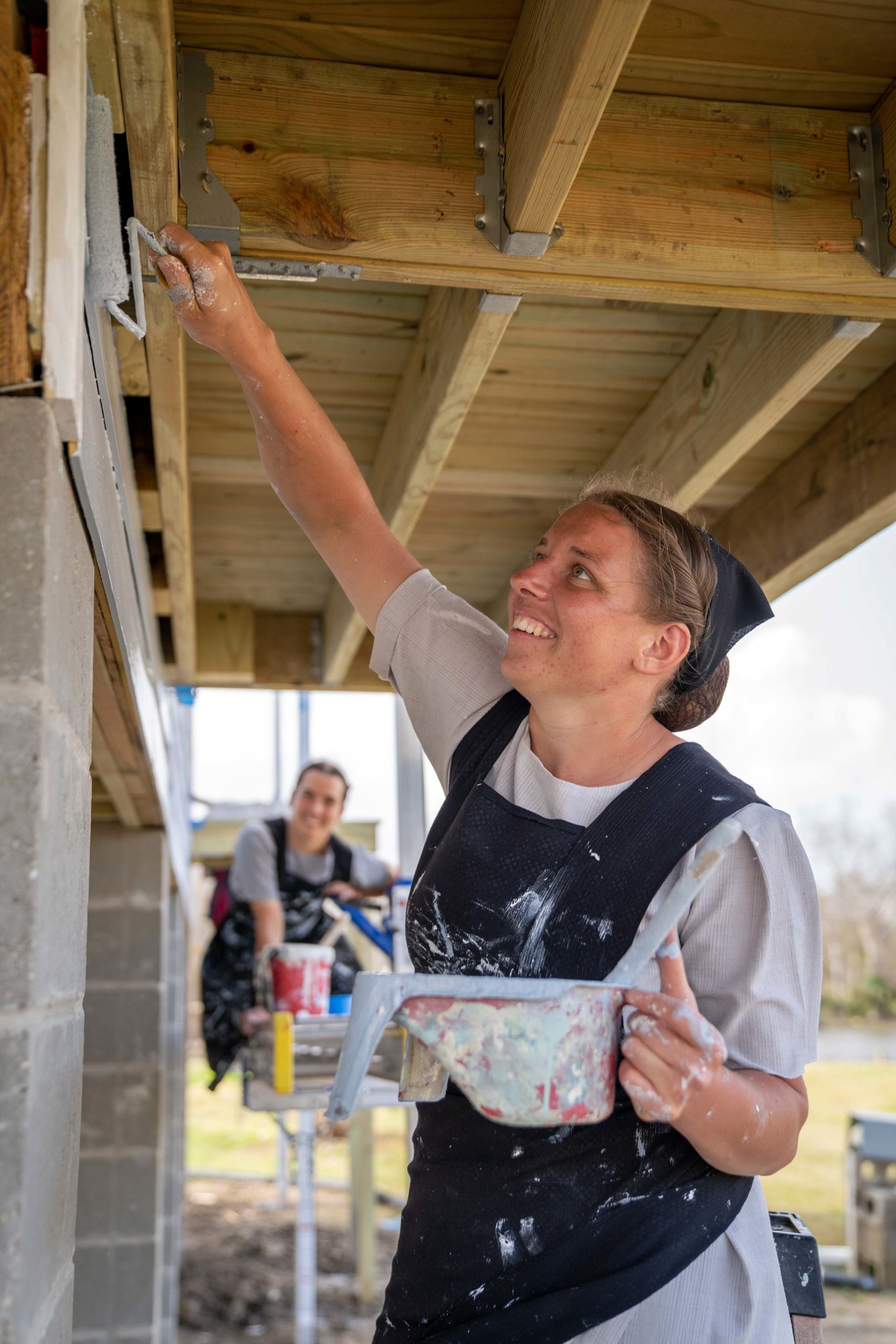 A photo of a volunteer painting the outside of a home in Dulac, Louisiana.