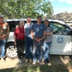 Weekly report photo from Paradise showing a group of long term volunteers standing in front of an MDS van