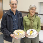 Jerry and wife holding retirement cakes in bee theme