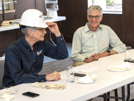 Jerry grosh sitting next to Kevin King while trying on a custom hardhat
