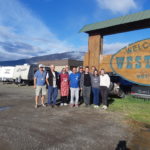 Monte Lake volunteer group photo outdoors in front of large wooden sign