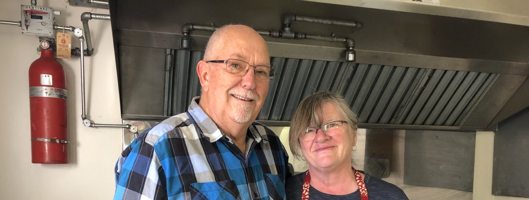 Helmut and Karin Hein pose for a picture inside of an MDS project kitchen.