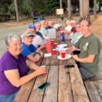Group photo of Paradise, CA volunteers for the week ending June 4, seated at a wooden table