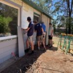 MDS volunteers work on siding a new build