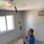 Volunteer in paradise working on interior finishes of a new build painting a ceiling