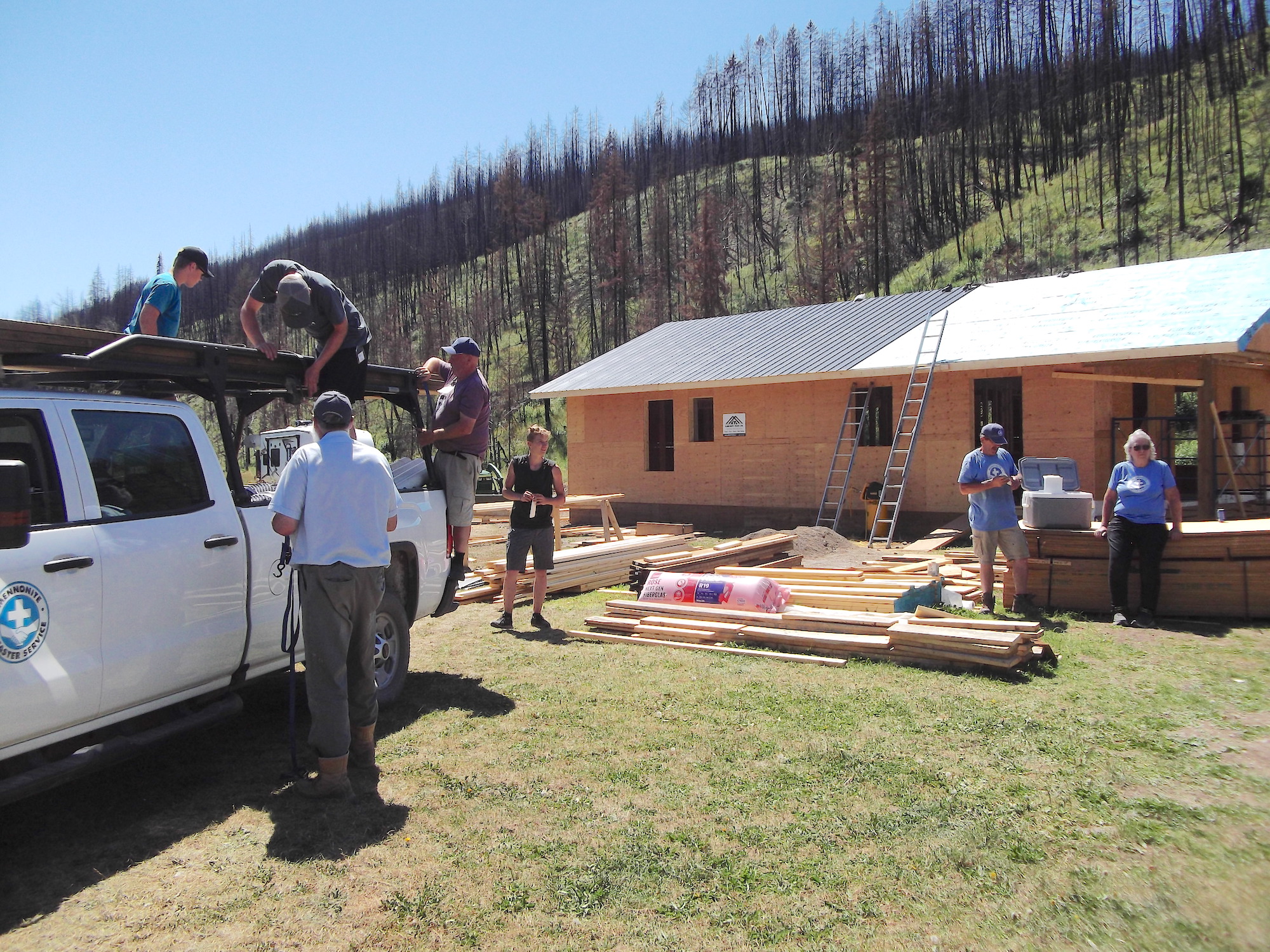 Volunteers are seen working with an MDS truck and new lumber