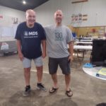 Todd Bomberger (gray shirt, weekly volunteer) and Jim (blue shirt, Jennings Church of Christ). Jim washes the MDS volunteers' dirty clothing each evening and returns the clean clothing the following day!
