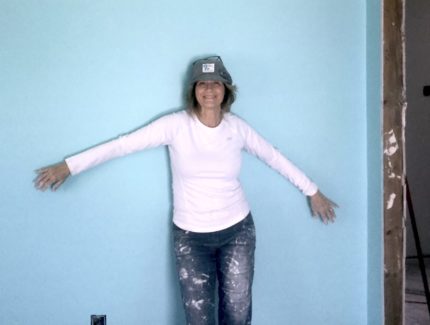 Evelyn Greenwood poses in front of a blue wall for a photo