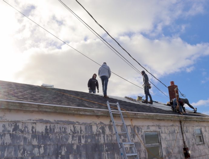 Volunteers work on the roof on Gerald Fukala's house in Glace Bay