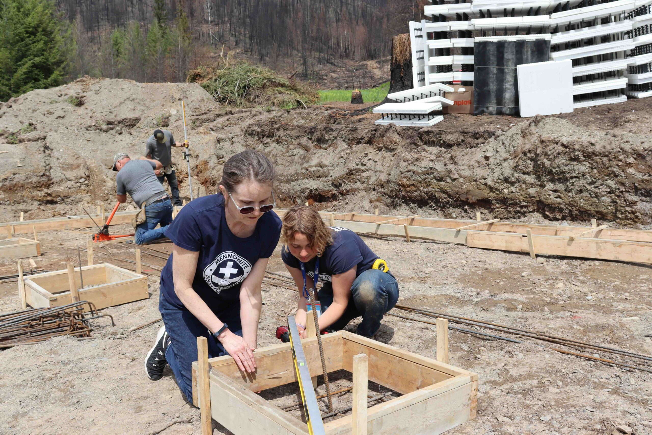 Rose Klassen, MDS Canada Volunteer Manager, and Hizee Pankratz, a MDS Canada Service Scholarship recipient, help prepare Isabelle Labelle and Jade Shamen's foundation in May 2024. MDS photo/Nikki Hamm Gwala 