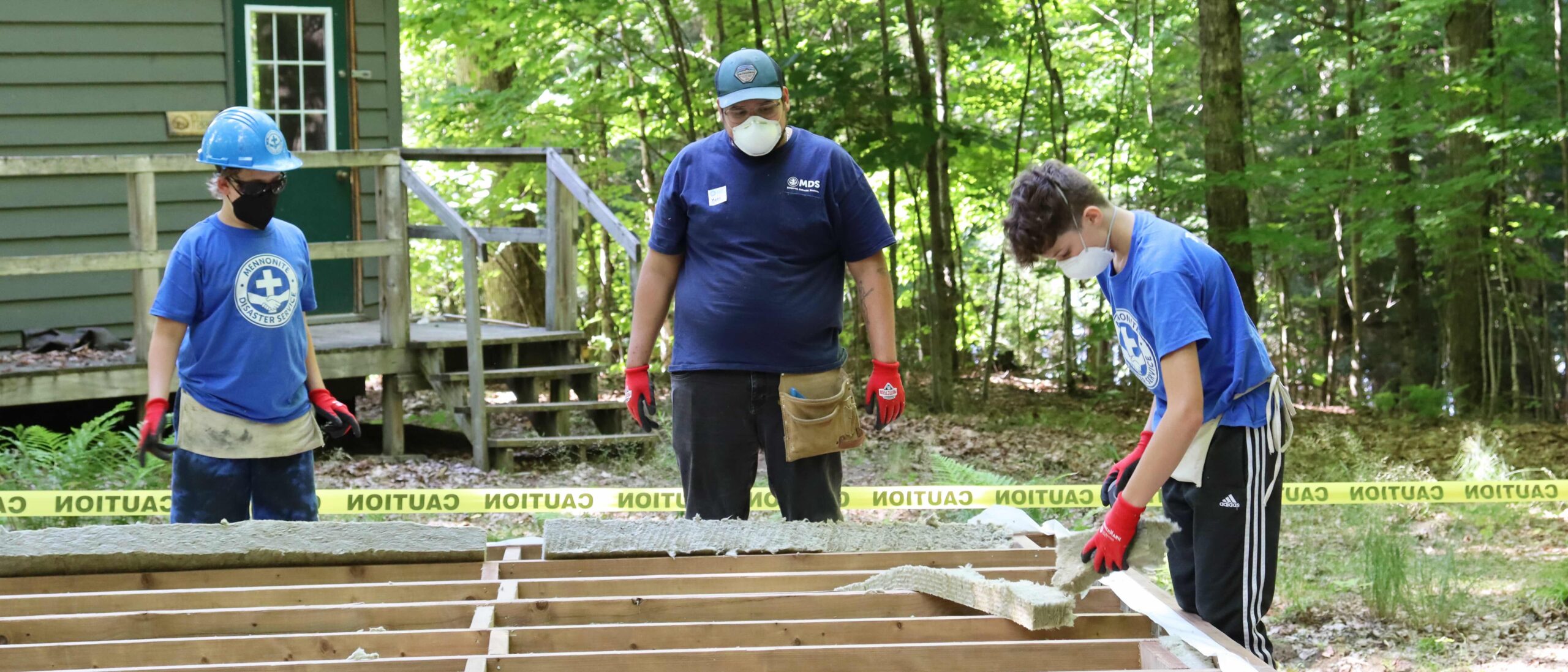 Mario Cruz offers direction to youth volunteers Amos Dick (left) and Ryan Fransen (right) as they install insulation.MDS photo/Nikki Hamm Gwala