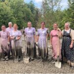 7 Women stand with shovels after mucking out 45 tons of material from a basement in Barre, VT.