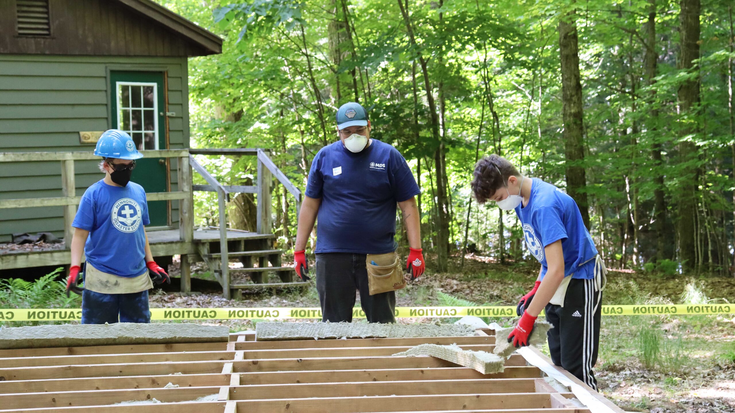 Three young people install insulation