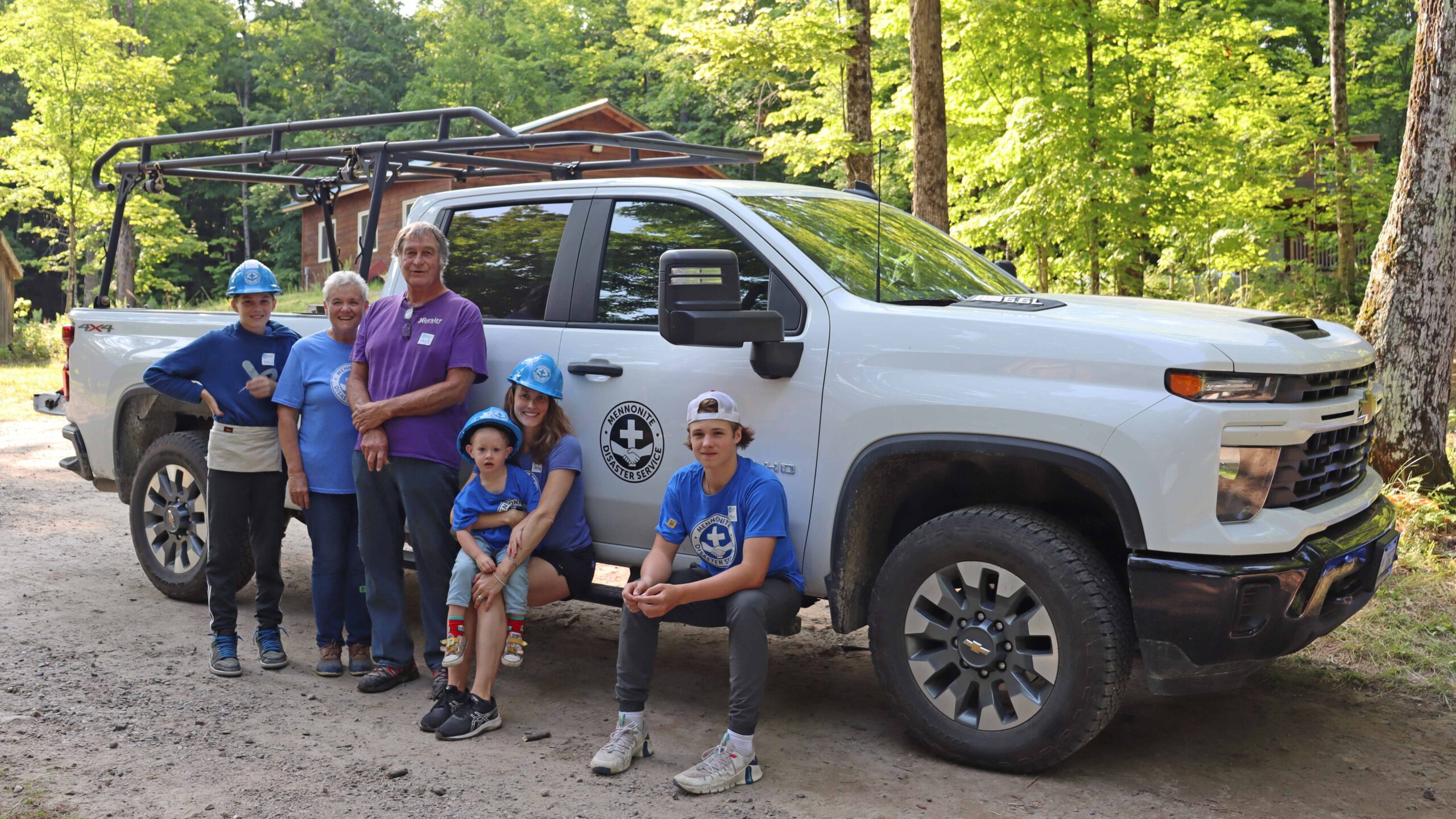 An intergenerational family photo with an MDS pickup truck in the background.