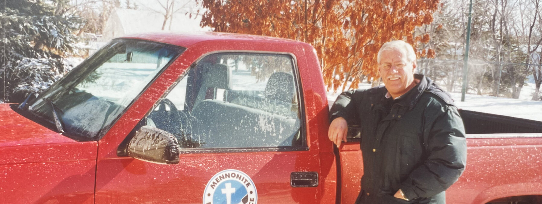 An MDS volunteer stands next to a red company truck.