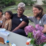 A family of four sits at a group dinner.
