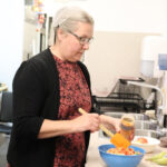 A woman dresses a salad