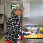 A woman prepares roasted sweet potato in a kitchen