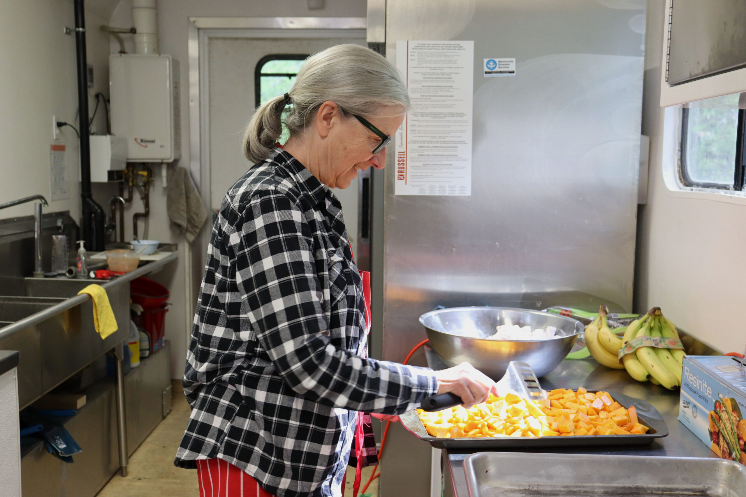 A woman prepares roasted sweet potato in a kitchen