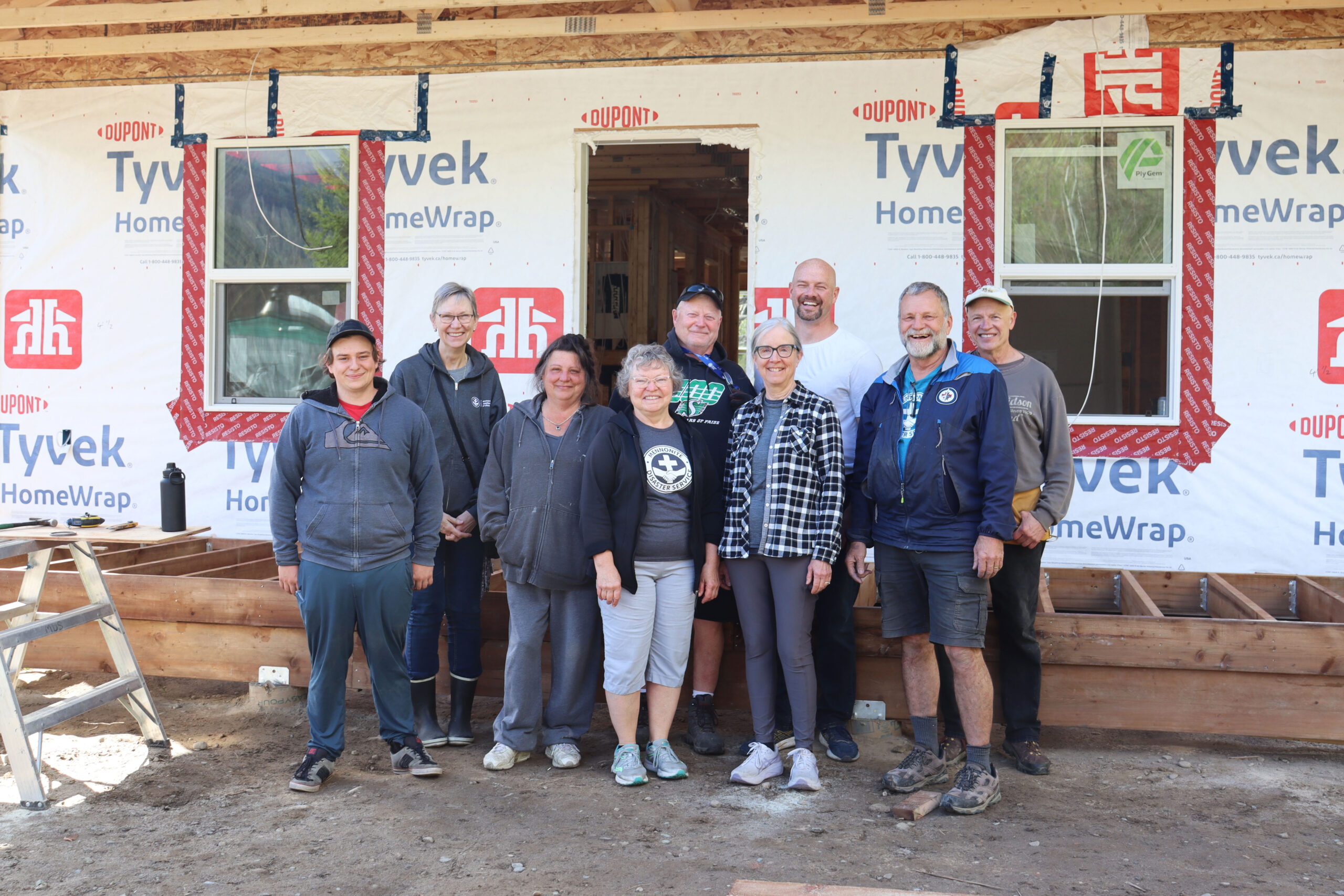 An MDS volunteer crew in front of a house under construction