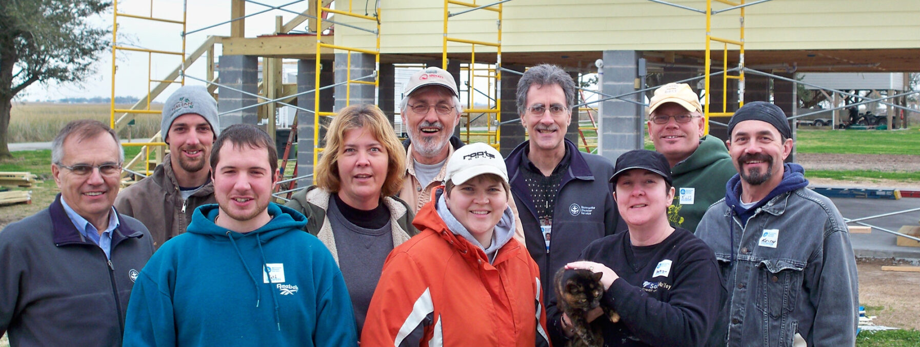 Group photo of MDS standing in front of elevated new build.