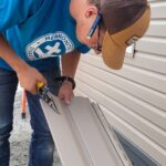 Man cuts vinyl siding.