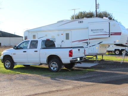 A white pickup truck and camper