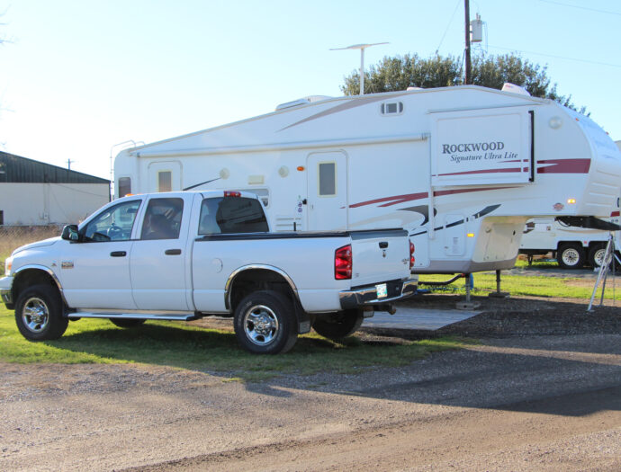 A white pickup truck and camper