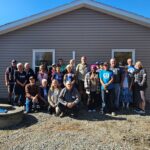 Group standing in front of new house build.