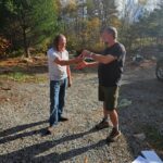Two men stanidng outside exchanging keys.