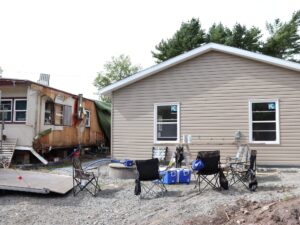 A mobile trailer on the left and a new house on the right.