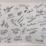 Signatures on a white sign.