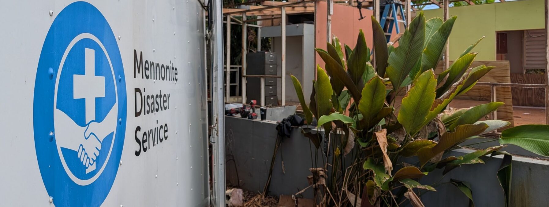 Trailer with logo beside a house under construction in Peurto Rico.