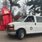 Van with driver in it beside iconic Canadian red cottae chair.